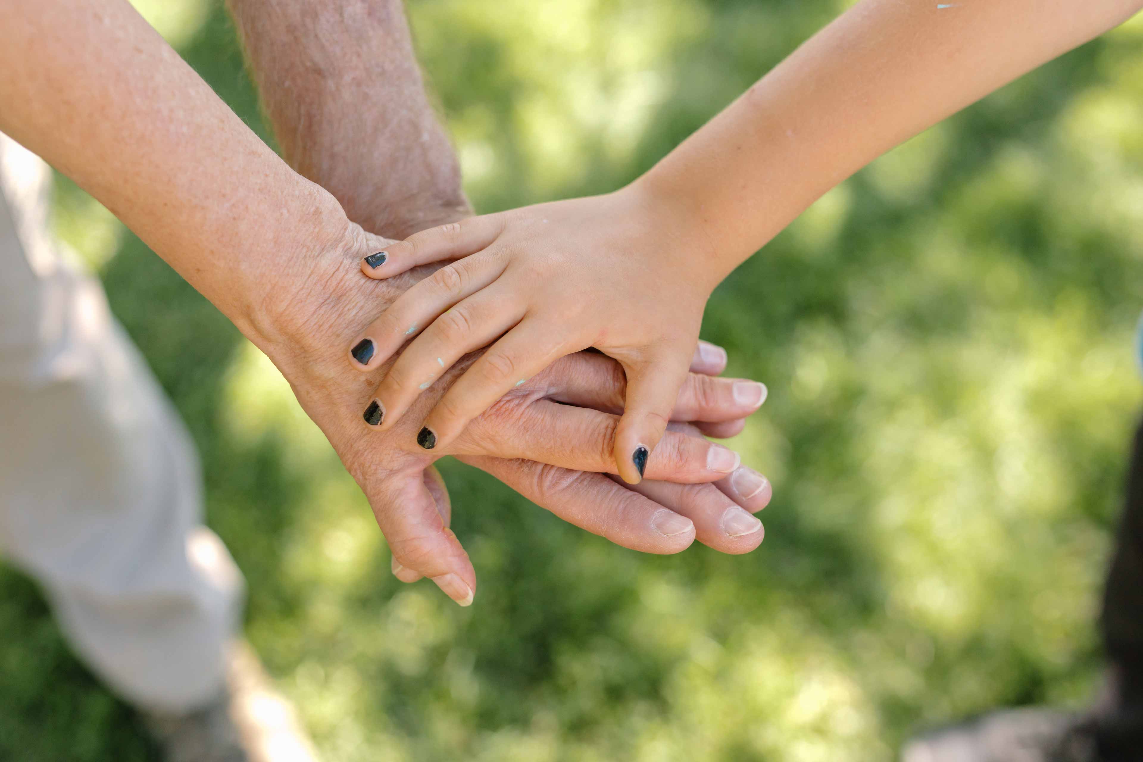 child holding hands with his parents