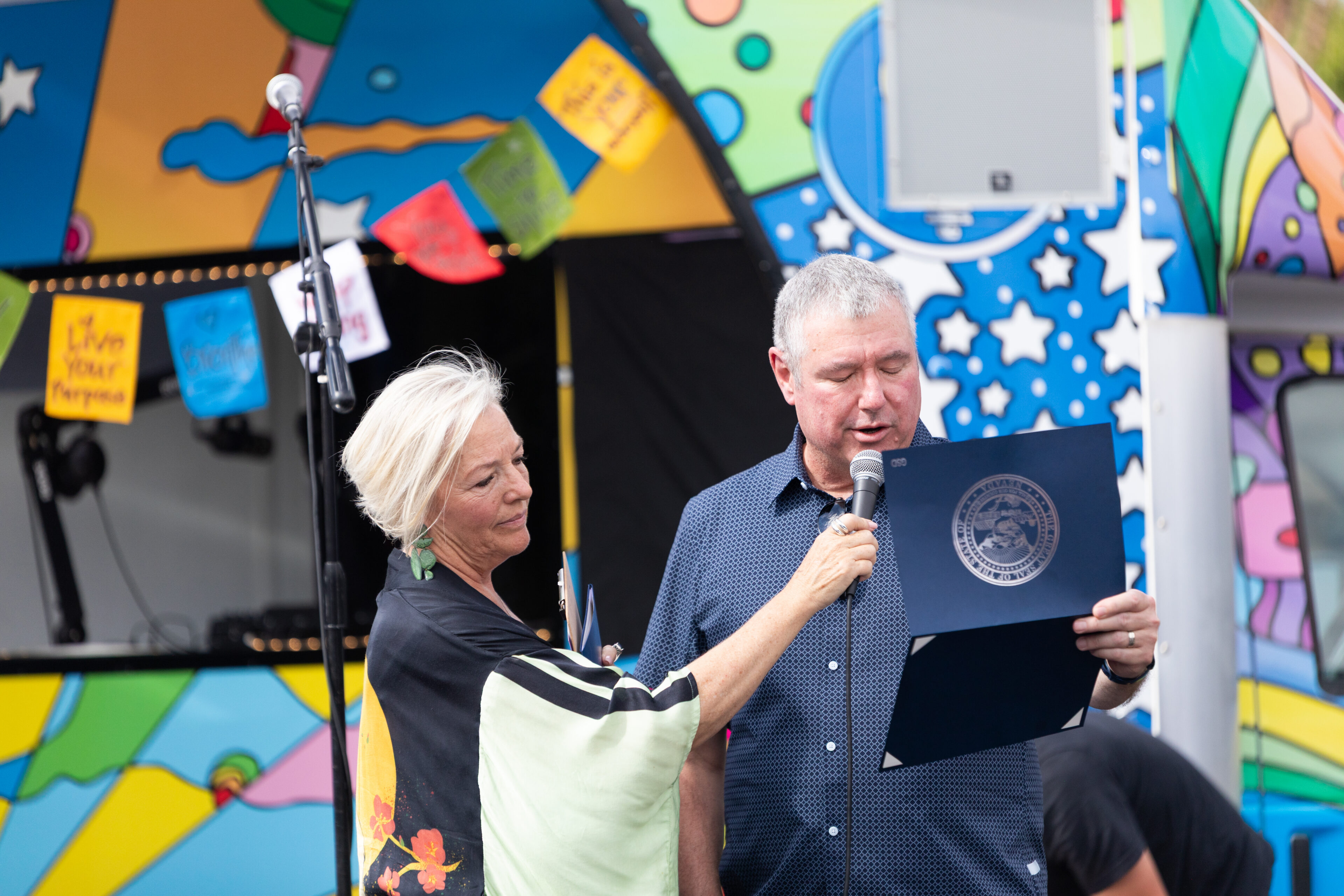 Carson Tahoe Health Board Chair Brian Duffrin reads a recognition on behalf of Nevada Governor, Joe Lombardo alongside Carson Tahoe Health Vice President of Community and Patient Experience Kitty McKay at the Dave Mason Legacy Dedication and Benefit Concert on Sunday, July 12, 2026 in Carson City, Nev. (Trevor Bexon/AP Content Services for Carson Tahoe Health)